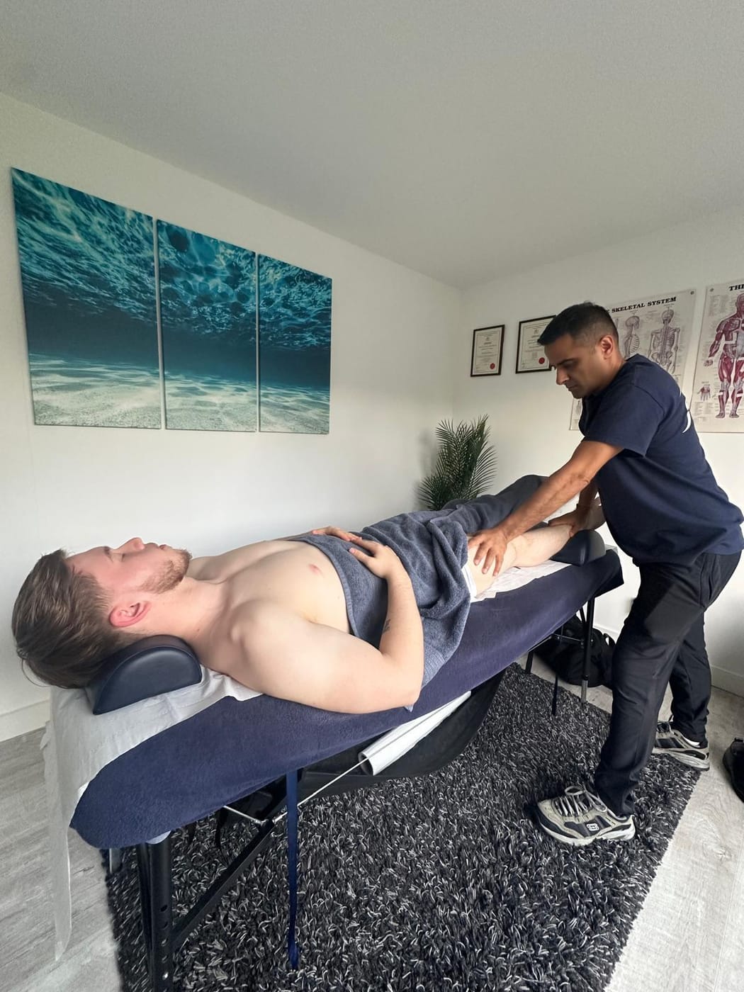 Pramod treating a client with hands-on sports massage in his Pinner clinic